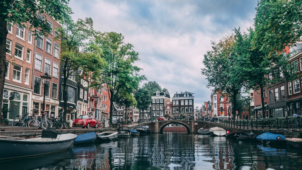 Crafting Captivating Headlines: Your awesome post title goes here Charming view of an Amsterdam canal lined with bicycles, boats, and historic buildings.